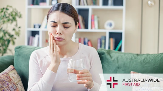 A woman experiencing tooth pain after drinking water